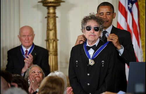 In den Jahren 1965 und 1966 geht Bob Dylan, der hier die Presidential Medal of Freedom von US-Präsident Barack Obama verliehen bekommt, unter die Buchautoren. Mit Tarantula entsteht eine Sammlung von Gedichten und prosaischen Texten – ein Seelenspiegel für Dylans kreative Entwicklung. Später sollte über das Buch geschrieben werden, es kombiniere die Menschlichkeit und das Mitgefühl seiner Wurzeln mit verspieltem Surrealismus moderner Kunst. Auch ein Abbild seiner Musik sollen die Texte sein, einen Sinn für Protest und Spontaneität haben, für die künstlerische Legitimität stehen, das Alltägliche abzubilden. Wieder und wieder verschiebt sich die Veröffentlichung des Bandes, unter anderem bedingt durch einen schweren Motorradunfall, bis Tarantula schließlich 1971 erscheint. Schon vor der Veröffentlichung erreicht das Buch dennoch Kultstatus, als wieder und wieder illegale Kopien, Manuskripte oder Proofexemplare an die Öffentlichkeit gelangen. Im Spin-Magazin erscheint im Jahr 2003 ein Artikel über die fünf unverständlichsten Sätze aus Büchern bekannter Rockstars. Souverän sichert sich Dylan den ersten Platz: „Now's not the time to get silly, so wear your big boots and jump on the garbage clowns.“ 