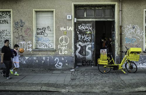 Ein Klassiker des Berliner Straßenbildes. Zeitlos, auch im Stau schnell auf der Straße und auch noch umweltfreundlich. Das Postfahrrard. Auf dem Bild zu sehen: Eins der knapp 20.000 Exemplare der Deutschen Post AG, hier in der Hausburgstraße 11 im Einsatz. Fahrräder wurden erstmals 1896 im Postdienst benutzt. Bei der Deutschen Bundespost wurden sie von Orts-, Land-, Eilzustellern und Briefkastenleerern sowie im Fernmeldeentstörungsdienst verwendet. Heute werden sie nur noch für die Zustellung von Briefsendungen eingesetzt. Wie lange das Postfahrrad in den aufkommenden Zeiten von Paketdrohnen noch zum Stadtbild gehört, bleibt fraglich. 