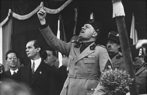 Benito Mussolini. 1883 geboren, wurde er 1925 Diktator. War er erst kritisch gegenüber Deutschland, näherte er sich immer weiter an - bis er im Juni 1940 dem Zweiten Weltkrieg beitrat. Da der Kampf erfolglos blieb, wurde Mussolini 1943 gestürzt und führte bis zu seinem Tod einen deutschen Marionettenstaat in Nord- und Mittelitalien.