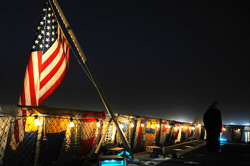 The Star-Spangled Banner an einer Gedenkstätte in Kuwait. Nur wenige Minuten nach der Befreiung von der irakischen Besatzung sah man die Bevölkerung bereits mit tausenden britischen und amerikanischen Flaggen wedeln. Was nach purer Freude aussah, war in Wirklichkeit detailreich inszeniert - von einer amerikanischen PR-Agentur. 