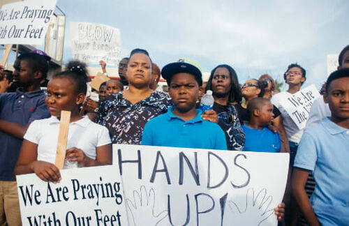 Nach dem Tod des Afroamerikaners Michael Brown lagen Krieg und Frieden in den USA eng beeinander: Nach einer ersten Mahnwache kam es zu Krawallen. Tausende überwiegend afroamerikanische Demonstranten hatten sich am Tatort versammelt. Die mit Schlagstöcken bewaffneten Einsatzkräfte der Polizei setzten Tränengas ein und versuchten, die Menge mit Hunden auseinanderzutreiben. Täglich kam es dann abends und nachts zu Unruhen in der Stadt. Nach der Entscheidung der Grand Jury, kein Strafverfahren zu eröffnen, flammten die Unruhen am 24. November wieder auf. Nach der Entscheidung der Grand Jury rief Michael Brown’s Stiefvater Louis Head zur Menge vor dem Police Department „Burn this bitch down!“ Ein Dutzend Gebäude wurde niedergebrannt, auch zwei Fahrzeuge der Polizei und verschiedene andere verbrannten.