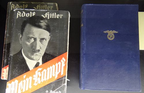 Das Corpus Delicti vieler öffentlicher Debatten: Hitlers Programmschrift „Mein Kampf“. Die zwei Bände entstanden in Hitlers Haftzeit 1924 und wurden bis Dezember 1926 veröffentlicht. Ab 1933 wurde das Buch zum Kassenschlager und finanzierte auch Teile der NSDAP. Bereits im Jahr der Machtergreifung wurden mehr als eine Million Exemplare verkauft – schon bald bekamen Brautpaare statt der Bibel eine Ausgabe des Buches zur Trauung. Bis 1939 stieg die Gesamtauflage auf 5,45 Millionen und erreichte bis 1944 10,9 Millionen Stück. Zum Vergleich: Die Startauflage der kritischen Edition des Instituts für Zeitgeschichte umfasst 4.000 Exemplare.