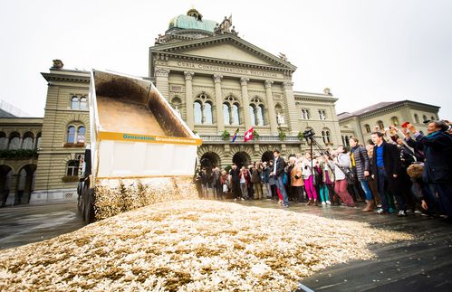 Gewinnausschüttung – im wahrsten Sinne des Wortes. Soweit wie bei dieser Demonstration für ein Bedingungsloses Grundeinkommen auf dem Berner Bundesplatz in der Schweiz wird es trotz Helikoptergeld nicht kommen. Selbst wenn die Europäische Zentralbank zu diesem Instrument greift – auf LKWs voller Geld in der Stadtmitte brauchen Bürger nicht zu hoffen. Auch wenn eine direkte Auszahlung an Bürger im Rahmen des Möglichen liegt, gehen Ökonomen von der Nutzung einer rechtlichen Hintertür aus. Von der EZB gedrucktes Geld dürfte zwar nicht direkt in nationale Staatshaushalte fließen, Experten bringen aber die Möglichkeit ins Spiel, dass ein öffentlicher Kreditgeber wie die Europäische Investitionsbank Anleihen zu einem Zins nahe Null herausgibt, die dann von der EZB aufgekauft werden. Auf diese Weise könnten öffentliche Investitionen finanziert werden.