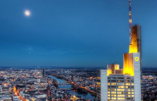 Strahlend, hell und fast trotzig ragt der Commerzbank-Tower in den Frankfurter Nachthimmel empor. 65 Stockwerke und Platz für 2.800 Menschen bietet das höchste Gebäude Deutschlands, das 1997 nach einem Entwurf von Architekt Norman Foster fertiggestellt wurde. Während die Commerzbank mit ihrer Konzernzentrale protzt, kämpft das Unternehmen gegen einen massiven Kursverfall: Rund 45 Prozent an Wert haben die Commerzbank-Aktien in diesem Jahr schon eingebüßt, seit dem letzten Stresstest zählt das Institut zu den zehn schwächsten Europas. Von den neun getesteten deutschen Instituten schnitt die zweitgrößte Bank Deutschlands am schlechtesten ab. Sie kam im Stressszenario auf eine harte Kernkapitalquote von 7,4 Prozent, womit sie europaweit auf Platz 44 liegt. Risikovorstand Marcus Chromik versucht zu beschwichtigen: „Die Commerzbank ist widerstandsfähig und stressresistent.“ Doch der freie Fall der Bank hält an.