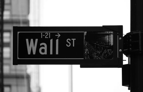 Großes Vorbild Wall Street? Hier im Herzen des New Yorker Finanzdistrikts ist der US-Aktienindex Dow Jones zuhause. Charles Dow stellte den Index 1884 zusammen, um die Entwicklung des US-amerikanischen Aktienmarktes zu messen. Der Dow-Jones-Index an der New York Stock Exchange ist nach dem Dow Jones Transportation Average der älteste noch bestehende Aktienindex der USA und setzt sich heute aus 30 der größten US-Unternehmen zusammen. Am 12. Januar 1906 stieg der Dow Jones mit einem Schlussstand von 100,25 Punkten zum ersten Mal über die Marke von 100 Punkten. Auf Grundlage des bis 1885 zurückgerechneten Index wurde die Grenze von 100 Punkten am 22. September 1916 mit einem Schlussstand von 100,77 Punkten erstmals überwunden. Weitere Meilensteine in der Entwicklung des Dow Jones waren die Überwindung der 1.000-Punkte-Marke 1972 und der 10.000-Punkte-Marke 1999.