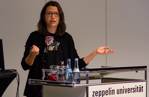 Wohin die liberale Weltordnung driftet, damit setzte sich die neue ZU-Professorin Lisbeth Zimmermann auch in ihrer Antrittsvorlesung auseinander. Zimmermann, geboren in Oldenburg, studierte nach dem Abitur in Alzenau Politikwissenschaft an der Freien Universität Berlin mit einem Stipendium der Studienstiftung des deutschen Volkes. Ihr wissenschaftlicher Weg führte sie im Rahmen des Exzellenzclusters „Herausbildung normativer Ordnungen“ jeweils als Promotionsstipendiatin an die Johann Wolfgang Goethe-Universität Frankfurt am Main, die Technische Universität Darmstadt sowie an das Leibniz-Institut HSFK. Aufenthalte als Gastforscherin führten sie unter anderem nach Washington D.C. und Florenz. Außerdem war Zimmermann Sprecherin der Nachwuchsgruppe der Sektion „Internationale Politik“ der Deutschen Vereinigung für Politikwissenschaft und Stipendiatin des Programms „Fast Track: Exzellenz und Führungskompetenz für Wissenschaftlerinnen auf der Überholspur“ der Robert Bosch Stiftung. Ihre Forschungsschwerpunkte liegen in den Bereichen aktuelle Herausforderungen einer multilateralen Weltordnung, Internationale Organisationen, Normen in den internationalen Beziehungen, Demokratie- und Rechtstaatlichkeitsförderung sowie Peacebuilding.