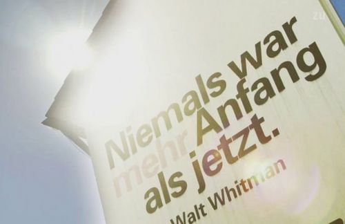 Als die „Außendarstellung“ der ZU noch philosophieren durfte: Walt Whitmans existentialistische Zeile vom immer währenden Anfang prangt in großen Lettern an der der Stadt zugewandten Ostwand des Gebäudes am Seemooser Horn, als (selbst-)motivierendes Aufbruchsversprechen. Rot abgesetzt das zentrale Wort: „mehr".