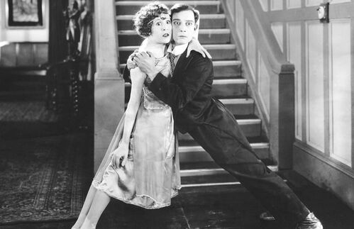 Neben Charlie Chaplin und Harold Lloyd zählt der 1895 geborene Buster Keaton zu den erfolgreichsten Komikern der Stummfilmzeit. Wegen seines bewusst ernsten, stoischen Gesichtsausdrucks wurde er „The Great Stoneface“ und „Der Mann, der niemals lachte“ genannt. Ein weiteres Markenzeichen war sein Porkpie-Hut, ein runder, flacher Hut aus Filz. Als Stummfilm wird seit der Verbreitung des Tonfilms in den 1920er-Jahren ein Film ohne technisch-mechanisch vorbereitete Tonbegleitung bezeichnet. Die Aufführung solcher Filme wurde zeitgenössisch fast ausnahmslos wenigstens musikalisch untermalt. Der Stummfilm entstand gegen Ende des 19. Jahrhunderts in Westeuropa und in den Vereinigten Staaten von Amerika. Weil es in der Frühzeit des Kinos noch keine zufriedenstellende Möglichkeit gab, Bild und Ton synchron aufzunehmen, wurden die Filme meist von Orchester, Klavier oder Grammophon begleitet. Stummfilme wurden auch mit einmontierten Texten, den Zwischentiteln, erzählt. Oft begleitete auch ein Filmerzähler oder -erklärer die Vorstellung. Trotzdem musste der Großteil der Handlung und Gefühle über die Filmbilder transportiert werden.