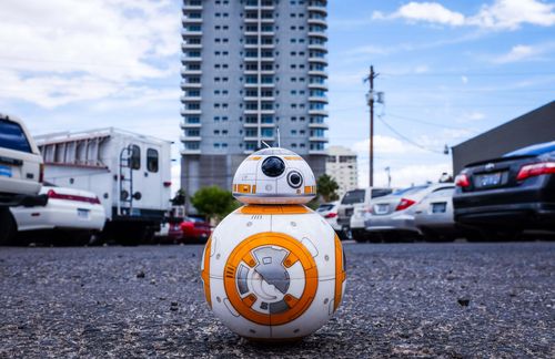 Auch wenn dieser Roboter aus dem Science-Fiction-Film Star Wars stammt und auf das Kürzel BB-8 hört, offenbart er eine mögliche Stoßrichtung, wie Künstliche Intelligenz im Alltag zum Einsatz kommen könnte – oder bereits im Alltag angekommen ist. Denn das Thema KI ist in den Verwaltungen Baden-Württembergs bereits angekommen. Erste Kommunen setzen Chatbots als automatisierte Serviceberater in den Bürgerbüros ein – 24 Stunden am Tag und 7 Tage die Woche. Innovative Start-ups entwickeln automatisierte Bilderkennungsverfahren zur Detektion von Straßenschäden, die zu signifikanten Kosteneinsparungen für die öffentliche Hand beitragen. Die Idee: Langweilige und fehlerträchtige Routineaufgaben können an Maschinen delegiert werden, sodass für die Menschen mehr Zeit für kreative und sinnstiftende Aufgaben bleibt. „Die Automatisierung von einfachen Routinetätigkeiten, die bisher manuell erledigt werden mussten, gilt neben vielen weiteren Potenzialen als Grundprinzip der Digitalisierung“, meint deshalb auch Prof. Dr. Wilhelm Bauer, Institutsleiter Fraunhofer IAO und Technologiebeauftragter des Landes Baden-Württemberg, in einem Vorwort zum Gutachten von Jan Etscheid und Prof. Dr. Jörn von Lucke.