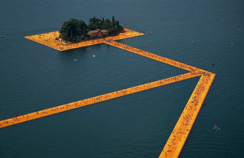 Vom 18. Juni bis 3. Juli 2016 ermöglichten es die Floating Piers von Christo und Jeanne-Claude 1,2 Millionen Menschen, auf dem oberitalienischen Iseosee über Wasser zu gehen. Es war das erste Großprojekt, welches Christo ohne seine Frau vollendete. Das Projekt, das aus 100.000 Quadratmetern schimmernden dahliengelben Stoffes bestand, die über ein modulares Stegsystem aus 220.000 Würfeln aus hochverdichtetem Polyäthylen gespannt waren, schuf drei Kilometer lange Gehwege über die Oberfläche des Sees und verband das Festland mit den Inseln Monte Isola und San Paolo. „Es geht vor allem um das Gehen“, meinte Christo zu dem Projekt. „Wenn man die Wegstrecke an Land mitrechnet, muss man fünf Kilometer laufen, um das Projekt richtig wahrzunehmen, die ständig wechselnden Ansichten, den See, die Berge, die anderen Besucher. Erst all dies zusammen ergibt das eigentliche Kunstwerk.“ Das Erlebnis war ebenso erfühlbar wie sichtbar, ein multisensorisches Wunder aus wogendem Stoff, schimmerndem Gelb und ständig wechselndem Licht auf dem Wasser.