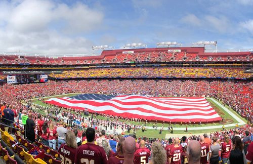 Am 14. August 2016 verändert sich das Leben von Colin Kaepernick für immer. Vor einem Trainingsspiel der San Francisco 49ers kommt es zu einem Eklat, als 240 Militärkräfte auf dem Footballfeld eine große US-Flagge präsentierten (Foto: Symbolbild) und Kaepernick, Quaterback und Anführer der einst stolzen Footballmannscchaft, sich für die US-amerikanische Nationalhymne, die vor jedem Spiel vorgetragen wird, nicht erhob. Mit seiner Weigerung wollte er gegen Rassismus und Polizeigewalt gegen Schwarze in den Vereinigten Staaten protestieren. „Ich werde nicht aufstehen und Stolz für eine Fahne demonstrieren, die für ein Land steht, das Schwarze und andere Farbige unterdrückt.“ Zahlreiche Spieler schlossen sich in der Folgezeit der Aktion an, was in den USA für hitzige Diskussionen sorgte, denn das Knien oder Sitzen bei der Hymne gilt als Respektlosigkeit. Für Kaepernick hatte die Aktion Folgen. 2017 wurde er bei den San Francisco 49ers entlassen, ein neues Team hat er bislang nicht gefunden.