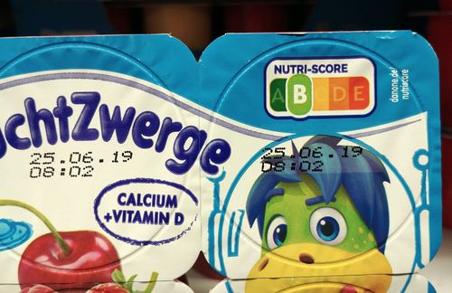 Welches Müsli trägt eher zu einer ausgewogeneren Ernährung bei? Wie gut ist die Nährstoffzusammensetzung meiner Pizza? Der sogenannte Nutri-Score ist ein klassisches Beispiel für sogenanntes Nudging – er beeinflusst die Kunden bei der Kaufentscheidung durch Transparenz und Wahlfreiheit. Denn per Blick auf die Lebensmittelampel können Verbraucher die Nährwertqualität von Lebensmitteln ganz einfach vergleichen – und freiwillig zu anderen Produkten greifen. Beim Nutri-Score zeigt eine fünfstufige Skala von A bis E, welche Nährwertqualität ein Produkt in der Gesamtschau hat. Dazu werden der Energiegehalt sowie die Gehalte ernährungsphysiologisch günstiger und ungünstiger Nährstoffe miteinander verrechnet und der Skala zugeordnet – von A (dunkelgrün) über C (gelb) bis E (rot). Als günstig eingestuft werden zum Beispiel die Gehalte an Ballaststoffen und Eiweiß sowie der Gehalt an Gemüse, Obst, Nüssen und Hülsenfrüchten. Als ungünstig gehen die Energie und der Gehalt an gesättigten Fettsäuren, Salz und Zucker in die Bewertung ein. Die Farben Grün bis Rot helfen bei der Orientierung: Ein grünes A trägt eher zu einer gesunden Ernährung bei als ein rotes E. Der Nutri-Score bezieht sich jeweils auf 100 Gramm oder 100 Milliliter eines Lebensmittels.