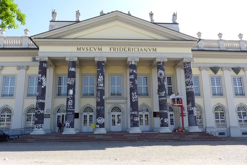 Fassade des Fridericianum mit Zeichnungen von Dan Perjovschi, der 2017 an der ZU seine gleichermaßen humorvollen wie scharfsinnigen zeitdiagnostischen Graffitis ausstellte.